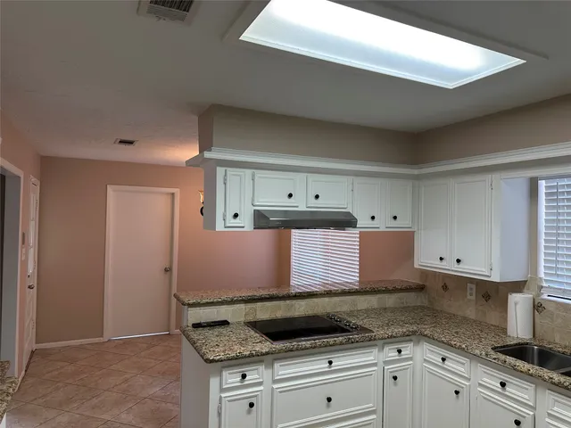 a kitchen with granite countertop a sink and a stove