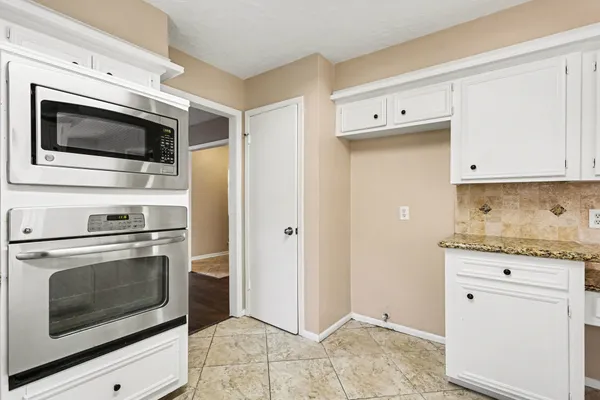 a view of an empty room with wooden floor and closet