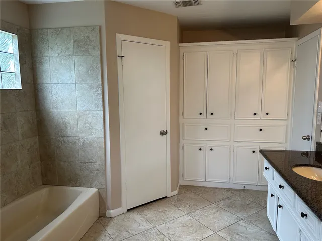 a spacious bathroom with a granite countertop tub sink and mirror