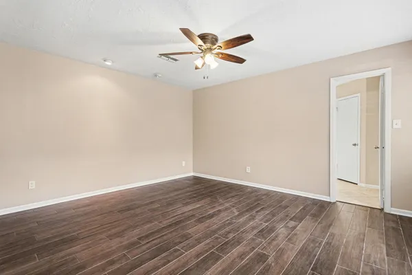 a view of a room with wooden floor and a ceiling fan
