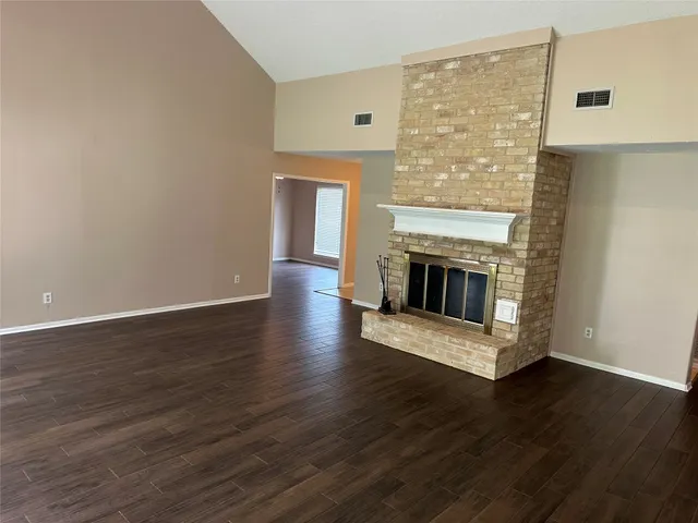a view of a livingroom with wooden floor and a fireplace