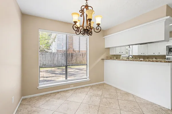 a view of an empty room with wooden floor fireplace and a window