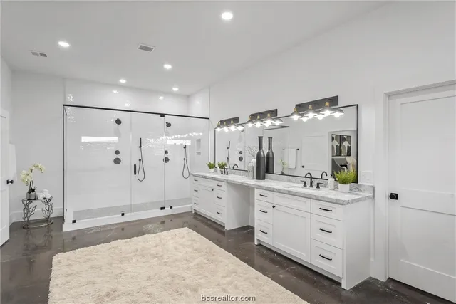 a spacious bathroom with a double vanity sink mirror and shower