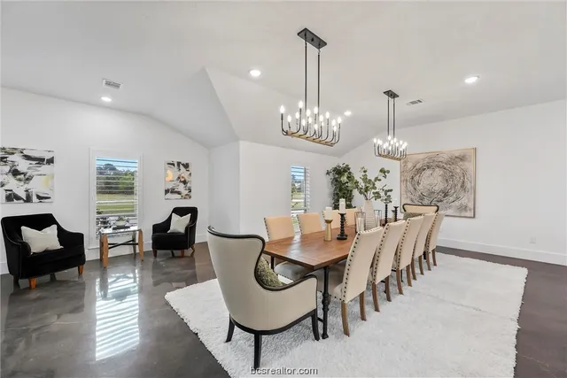 a view of a dining room and livingroom with furniture wooden floor a chandelier