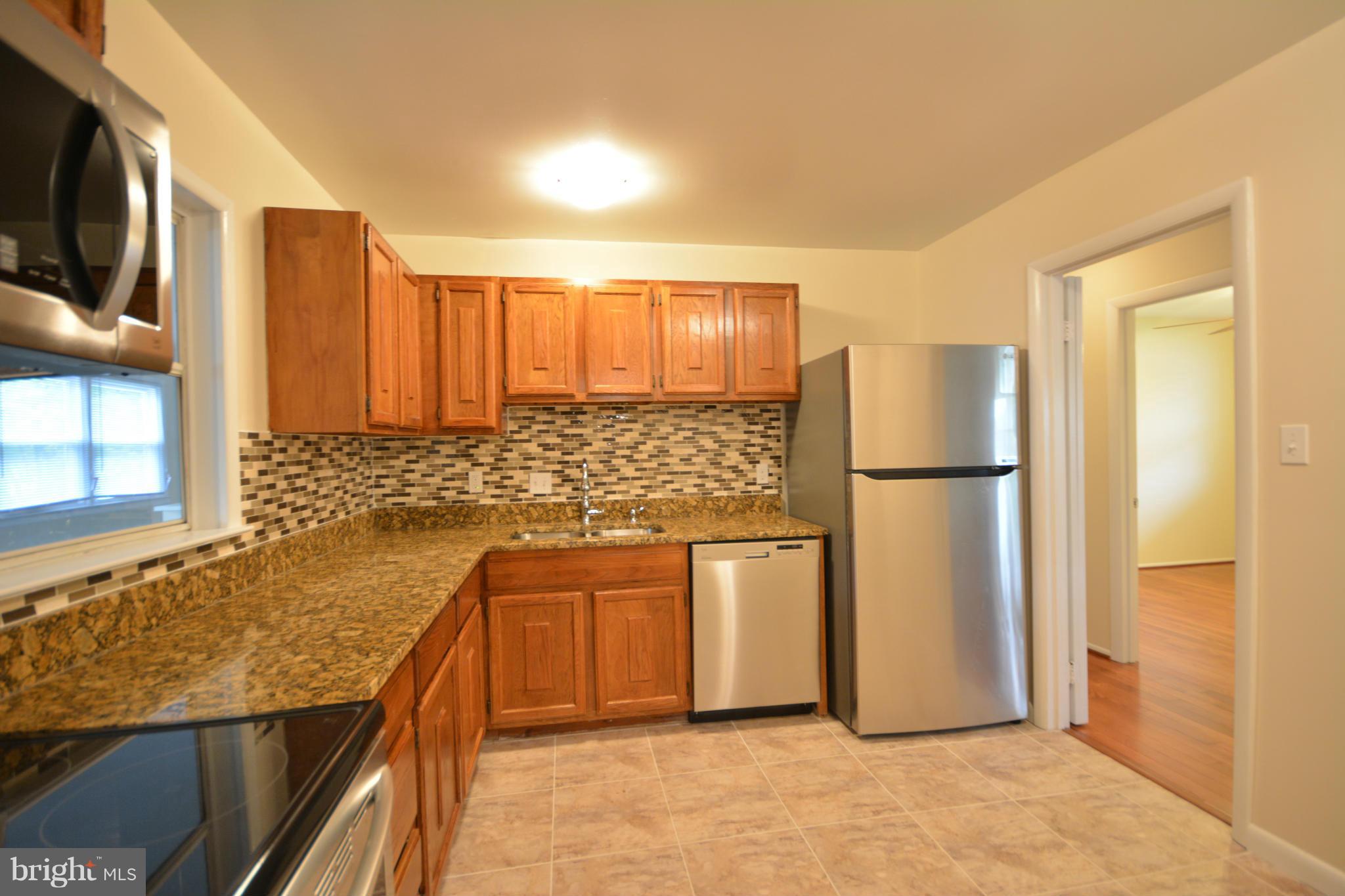 13203 Delaney Road Woodbridge, VA 22193 - Photo 20 of 30 a kitchen with white cabinets and stainless steel appliances