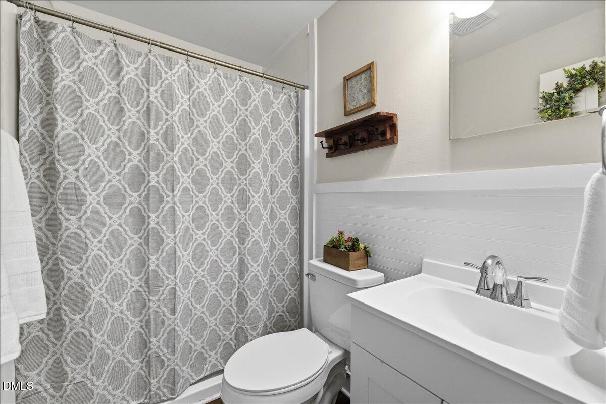 809 Dupree Street Durham, NC 27701 - Photo 15 of 24 a bathroom with a sink a toilet and shower curtain
