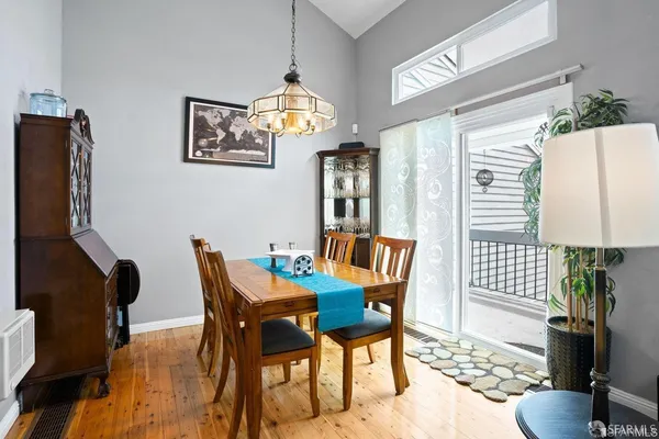 a view of a dining room with furniture a chandelier and wooden floor
