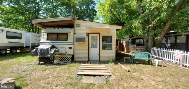 a backyard of a house with barbeque oven and outdoor seating
