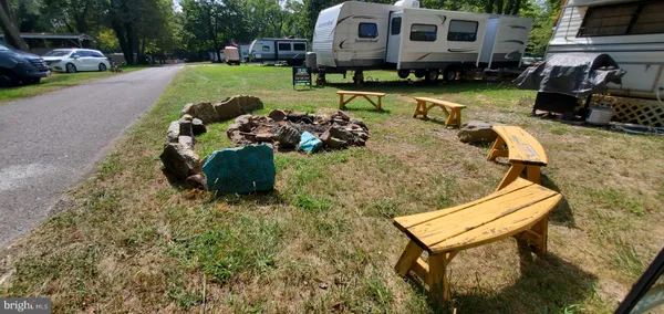 a backyard of a house with barbeque oven and outdoor seating