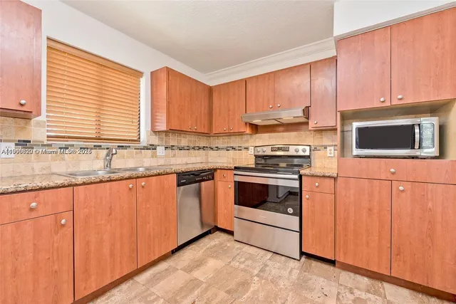 a kitchen with granite countertop white cabinets and white appliances