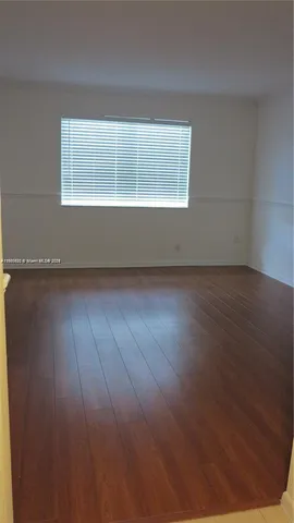 a view of wooden floor and windows in a room