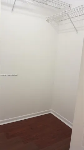 a view of a small space with wooden floor and a window