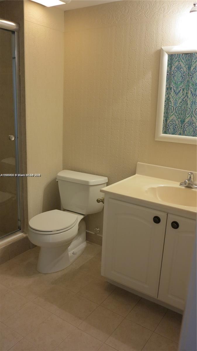 350 Lakeview Drive, Unit 201 Weston, FL 33326 - Photo 8 of 14 a white toilet sitting next to a bathroom sink