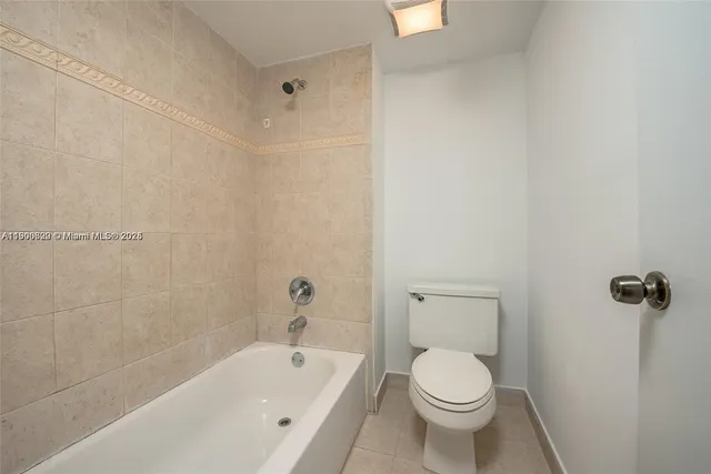 a white toilet sitting next to a bath tub and a shower