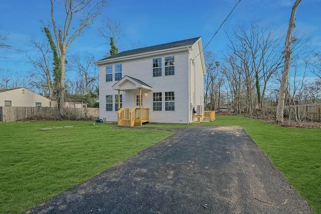 a view of a house with backyard and a tree