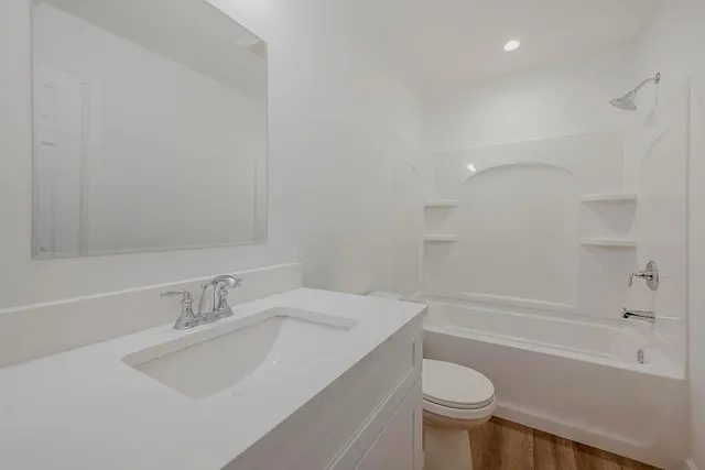 a bathroom with a sink toilet vanity and bathtub