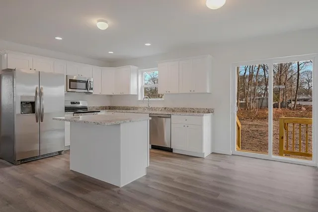 a kitchen with granite countertop a sink cabinets and stainless steel appliances