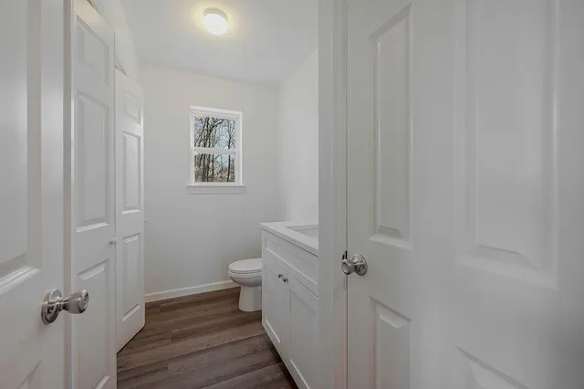 a bathroom with a granite countertop toilet and a sink