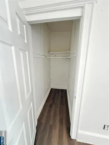 a view of a closet with wooden floor