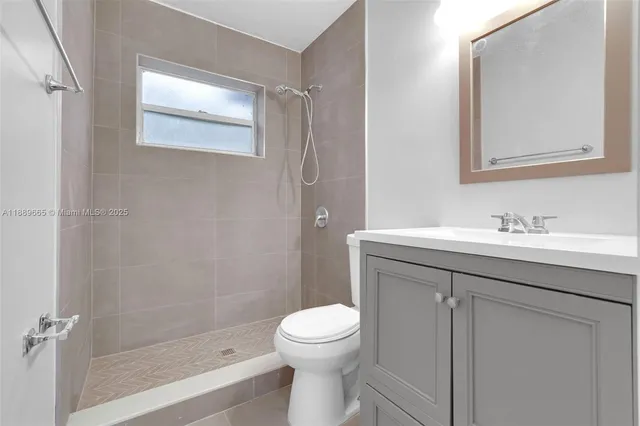 a bathroom with a sink mirror toilet and vanity