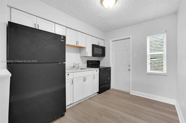 a kitchen with a refrigerator and a stove top oven