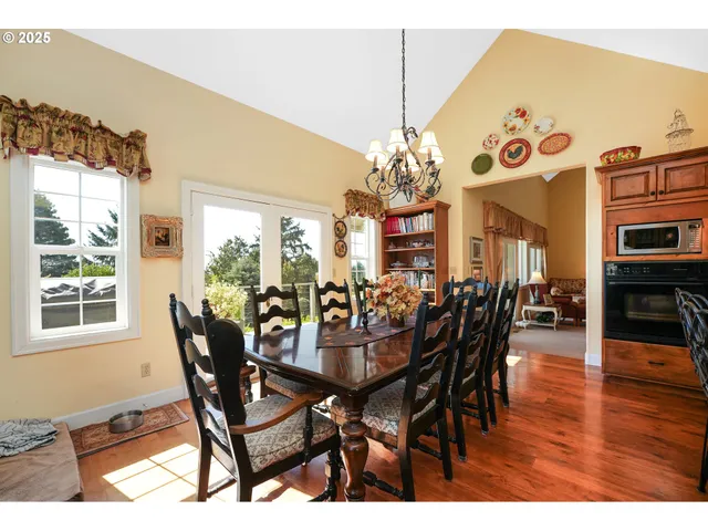 a view of a dining room with furniture a chandelier and wooden floor