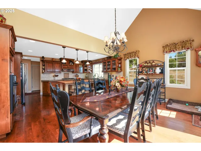 a dining room with furniture a chandelier and wooden floor
