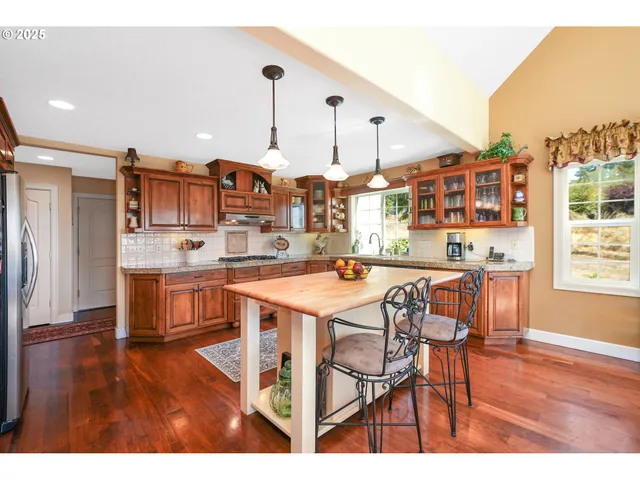 a open kitchen with stainless steel appliances granite countertop a stove and a refrigerator