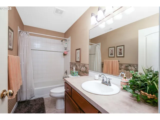 a bathroom with a sink vanity granite toilet and a mirror