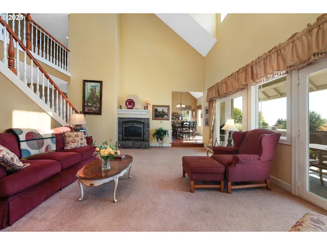a living room with furniture a fireplace and a large window