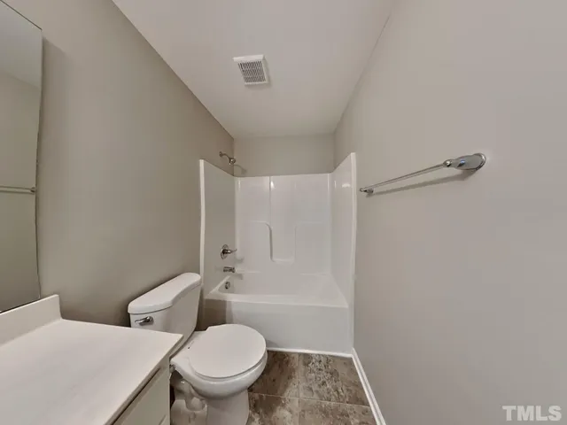 a white toilet sitting next to a bathroom sink and a shower