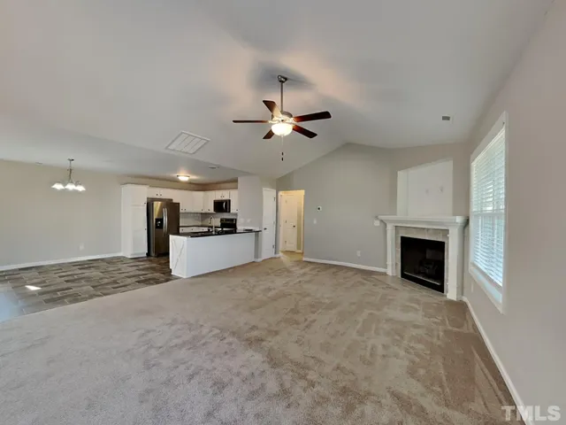 a view of a livingroom with a fireplace and a ceiling fan