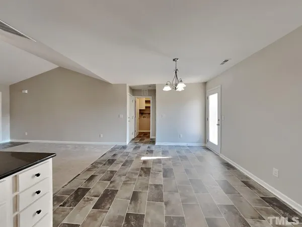 a view of an empty room with a kitchen