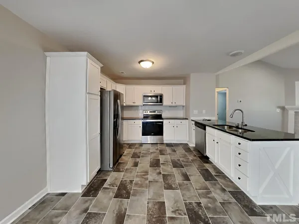 a kitchen with granite countertop a refrigerator and a sink