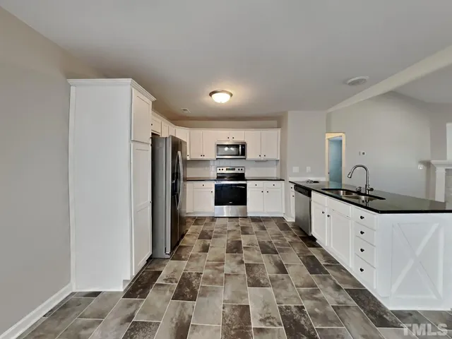 a kitchen with granite countertop a refrigerator and a sink
