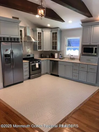 a large kitchen with stainless steel appliances and a refrigerator