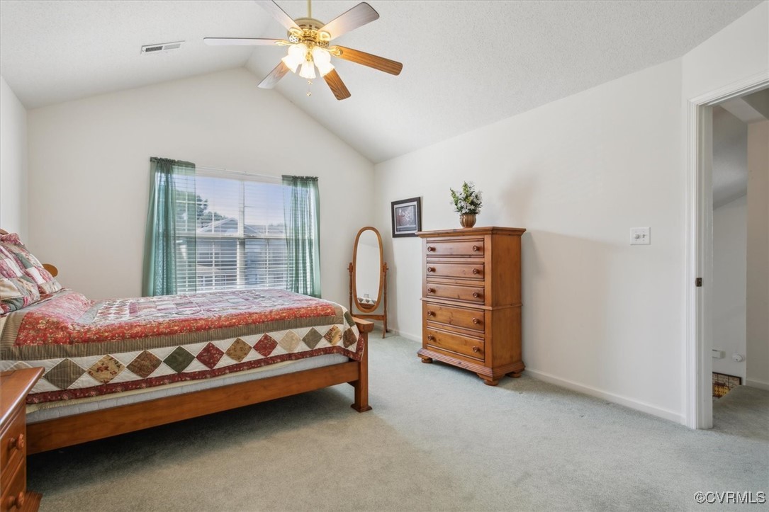 2104 Westgate Circle Williamsburg, VA 23185 - Photo 32 of 45 a bed sitting in a bedroom next to a window and a chandelier