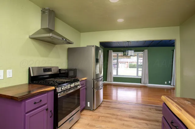 a kitchen with stainless steel appliances granite countertop a stove a sink and a refrigerator