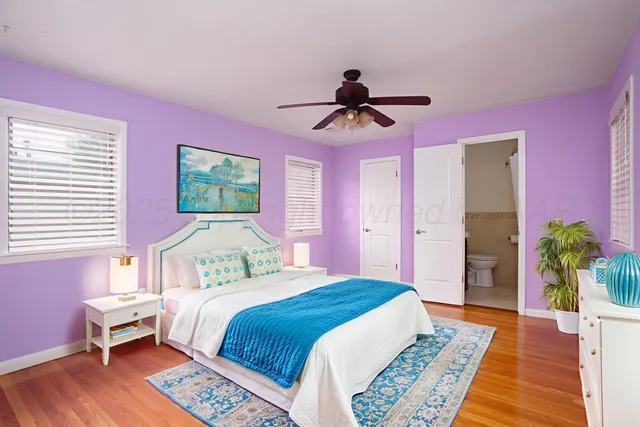 a bedroom with a bed a chandelier and a rug