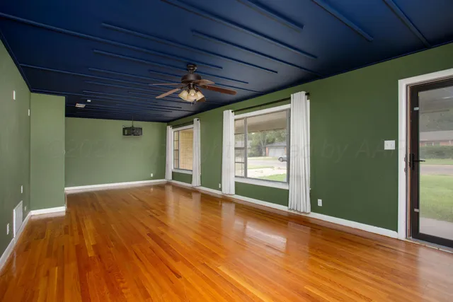 a view of empty room with wooden floor