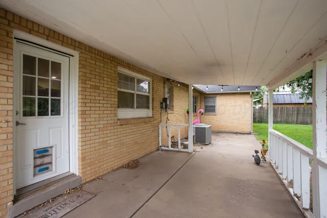 a view of a porch with furniture and a yard