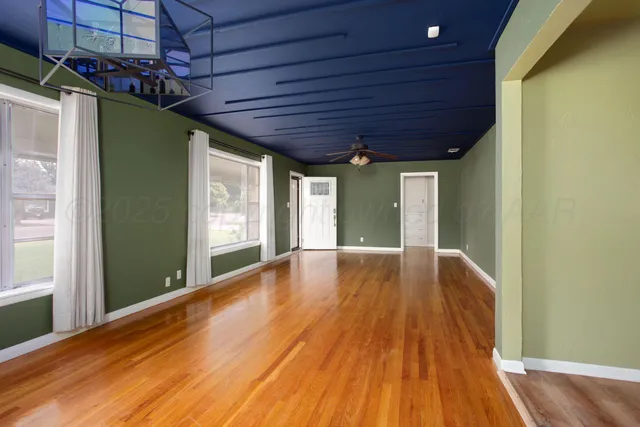 a view of empty room with wooden floor