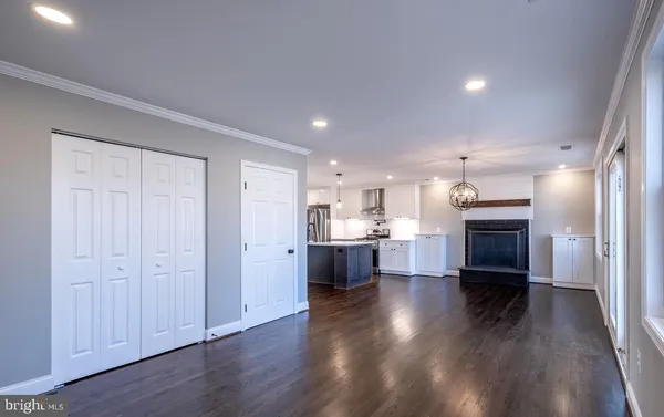 a living room with stainless steel appliances kitchen island wooden floors and view living room
