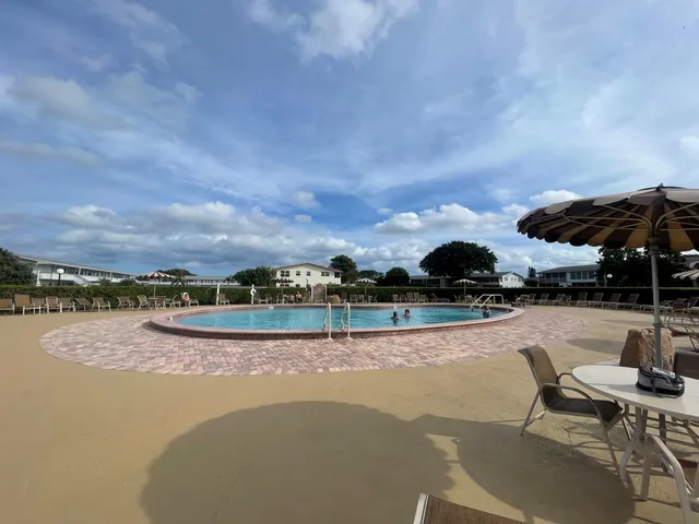 a view of swimming pool with outdoor seating and a garden