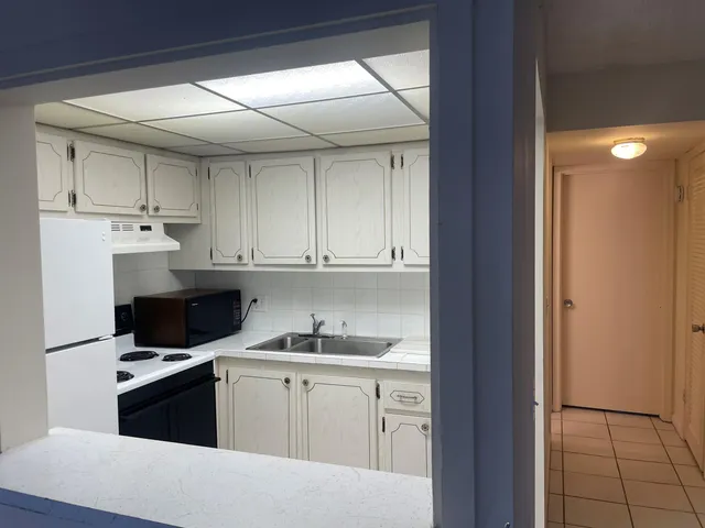a kitchen with kitchen island a sink a stove and refrigerator