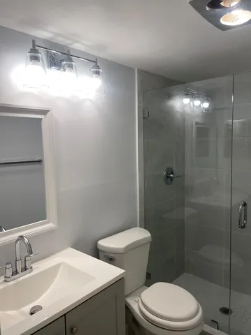 a bathroom with a sink a toilet and shower
