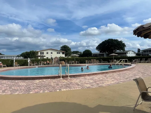 a view of swimming pool with outdoor seating and barbeque oven in the back