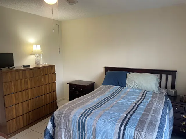 a bedroom with a bed and a flat tv screen on dresser