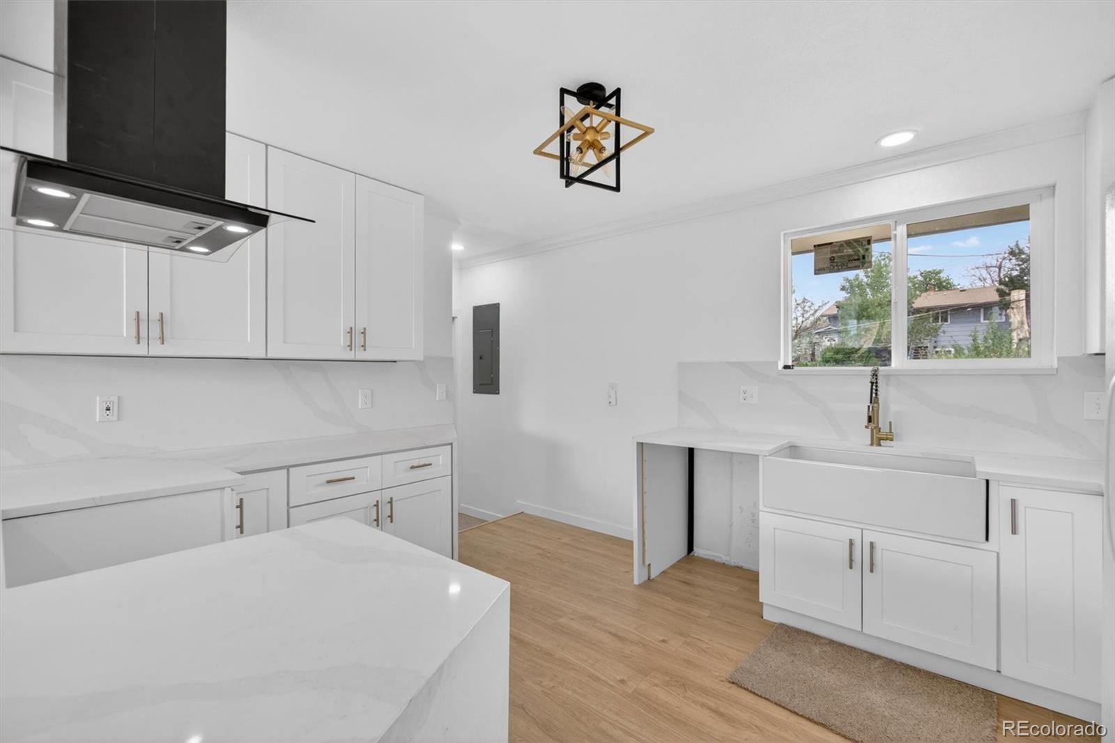7620 Acoma Court Denver, CO 80221 - Photo 15 of 39 a kitchen with a refrigerator and white cabinets