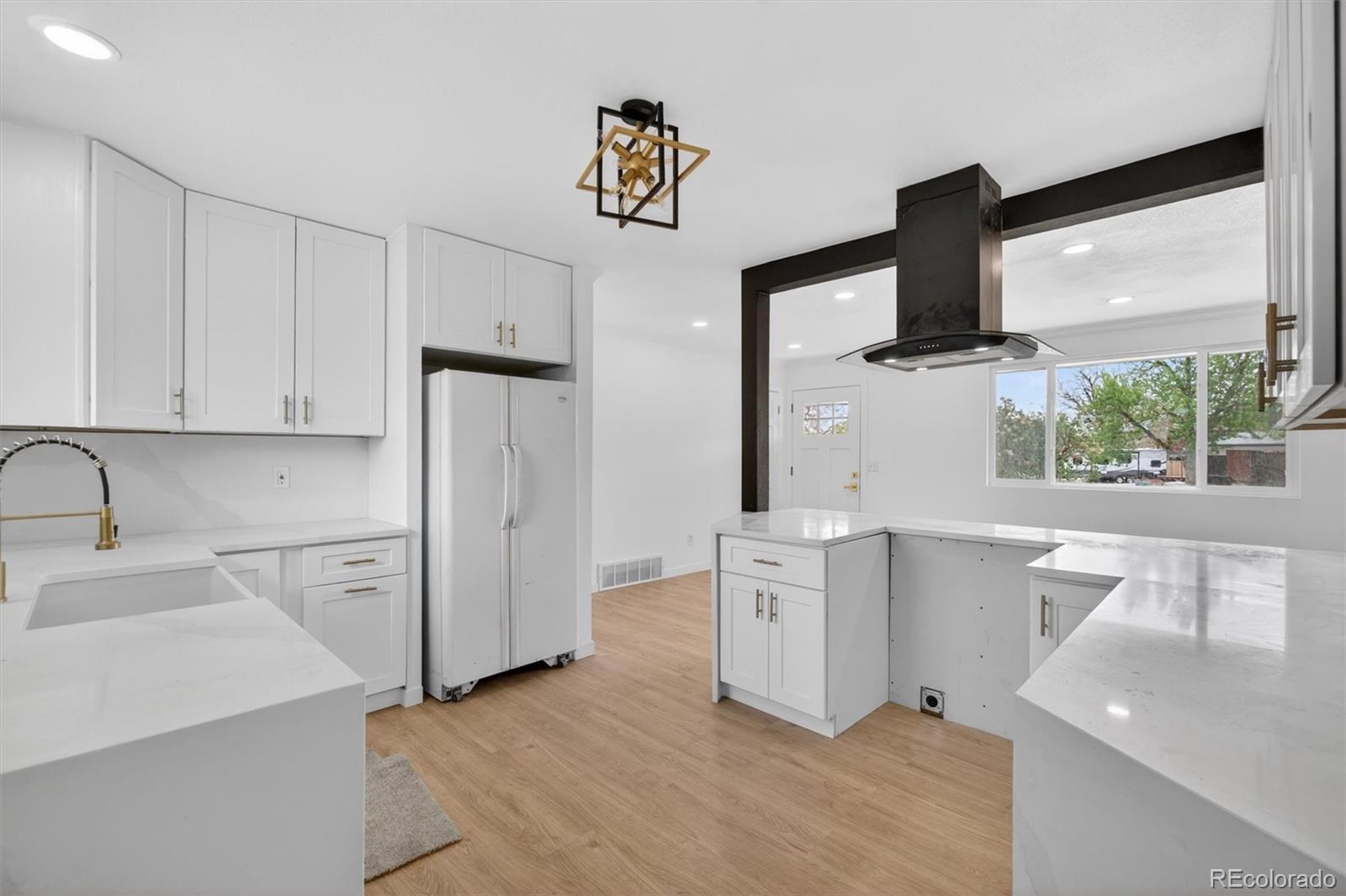 7620 Acoma Court Denver, CO 80221 - Photo 16 of 39 a kitchen with stainless steel appliances a white refrigerator a sink a stove and white cabinets with wooden floor